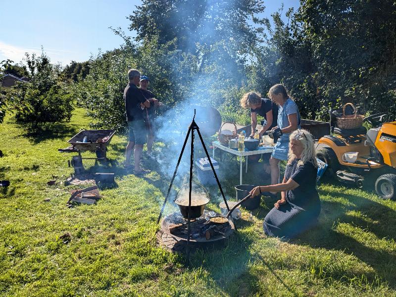 En lille flok mennesker samles om bål i en flot have